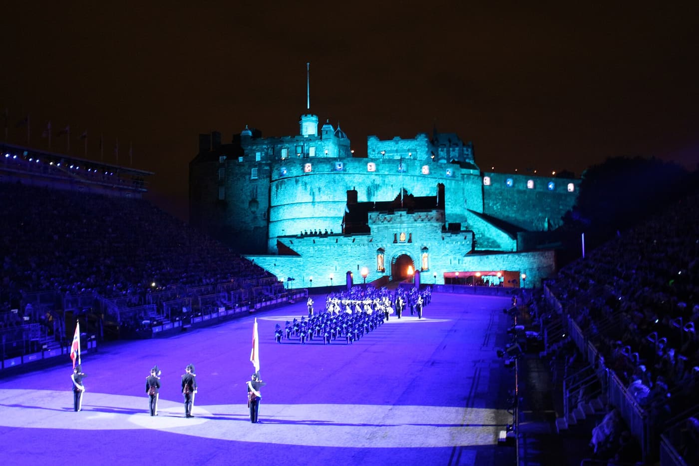 Edinburgh Castle lit in blue above the arena of the Royal Edinburgh Military Tattoo