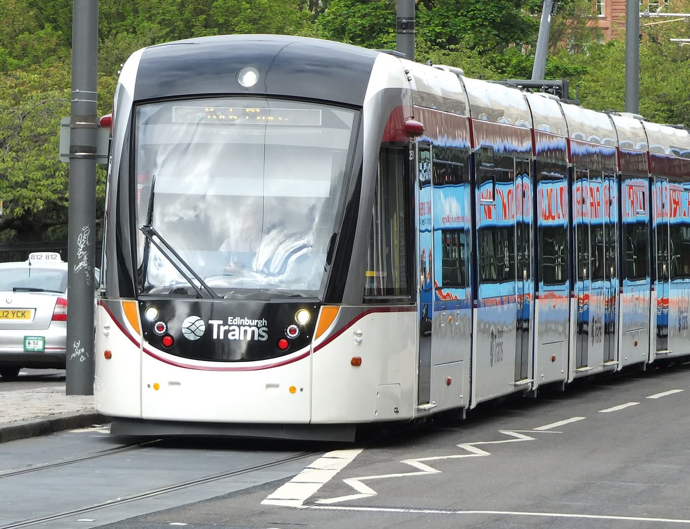 A white Edinburgh tram on a city street