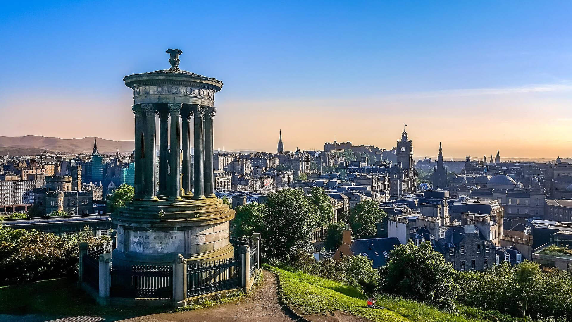 The Dugald Stewart Monument on Calton Hill with the Edinburgh skyline and castle beyond at dusk